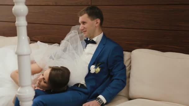 Pareja feliz boda relajante en el sofá en la cafetería vintage. Concepto día de boda . — Vídeos de Stock