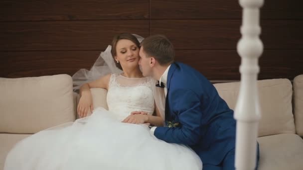 Primer plano de la pareja feliz boda relajarse y coquetear entre sí en el sofá blanco en el lujoso café. Momento de felicidad — Vídeos de Stock