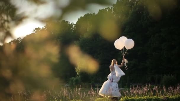 Sinnlicher Moment der Liebe. glücklicher Bräutigam Carryes in den Händen schöne blonde Braut mit Luftballons. sonniger Sommer Feld Hintergrund — Stockvideo