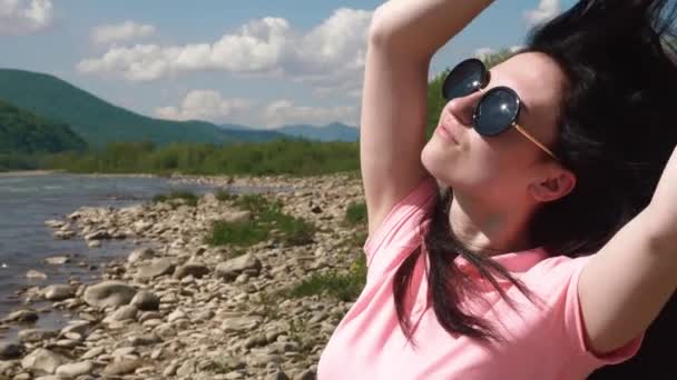 Csinos, fiatal, barna nő élvezhetik a napsütést a kültéri részlete. Folyó háttér — Stock videók