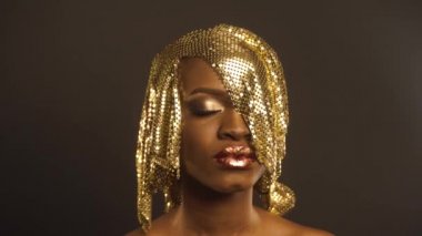 Afrika kökenli Amerikalı kadınla parlak parlak altın makyaj moda portre. Bronz Bodypaint, siyah stüdyo arka plan