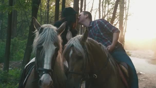 Close-up de um casal de jóquei bonito no amor montando cavalos e beijando. Momento sensual de amor e harmonia. Encantadora paisagem inglesa — Vídeo de Stock