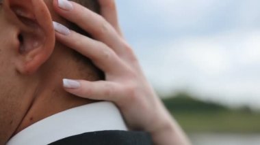 Yakın çekim yumuşak kucaklayan güzel genç bir çift. Güzel el mamülleri yüzünü okşayarak gelinin. An aşk