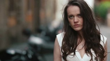 Güzel çiçek buketi ile caddenin üzerinde yürüyen genç ciddi ve çekici kadının ileri atış