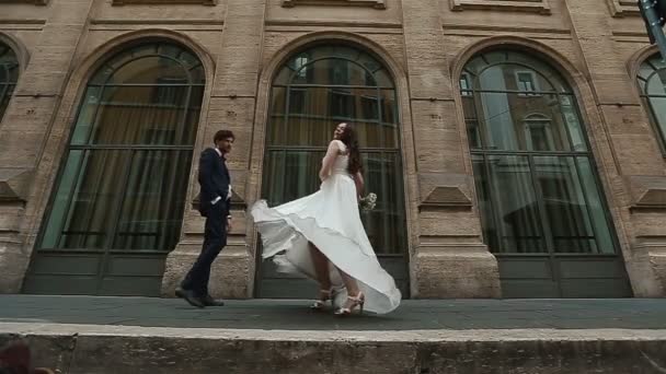 Γαμήλιο ζευγάρι χορούς στον παλιό δρόμο μπροστά από το μεγάλο εκλεκτής ποιότητας προθήκες ευρωπαϊκή πόλη — Αρχείο Βίντεο