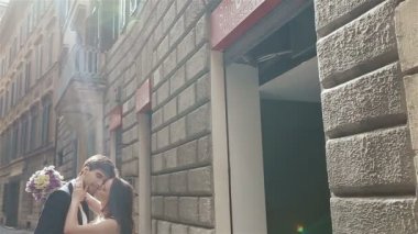 Güzel düğün çift, sarılma ve öpüşme Avrupa City vitrinler ile eski house yakınındaki sokak yakışıklı damat ile zarif gelin