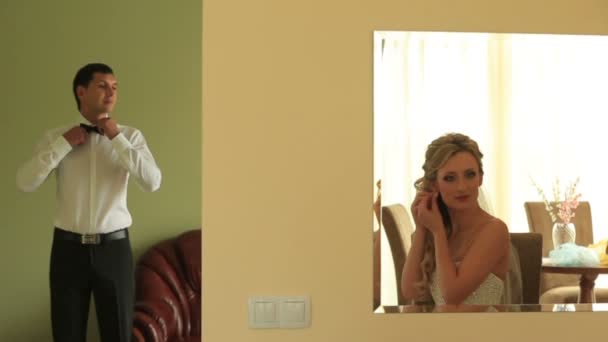 Feliz joven novio y novia preparándose para su gran día en sus apartamentos — Vídeos de Stock