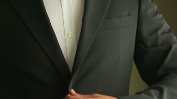 Concepto de boda. Primer plano del novio en esmoquin ajustando su corbata . — Vídeos de Stock
