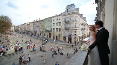 Genç lüks muhteşem mutlu gelin ve damat Balkonda duran. Güneşli antik Lviv kenti arka plan