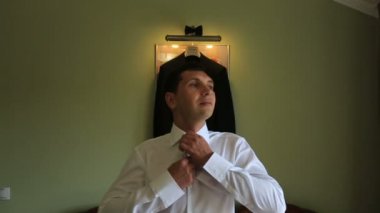 Şık ve yakışıklı damat düğün günü sabahı gömleğini ayarlar. Hazırlık