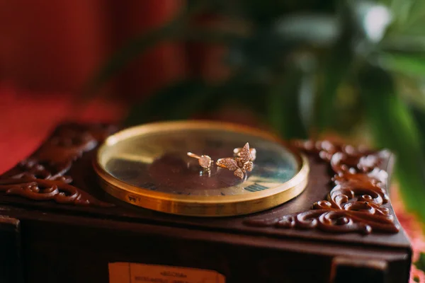 Three golden rings lie on the dial of old vintage clock indoors — Stock Photo, Image