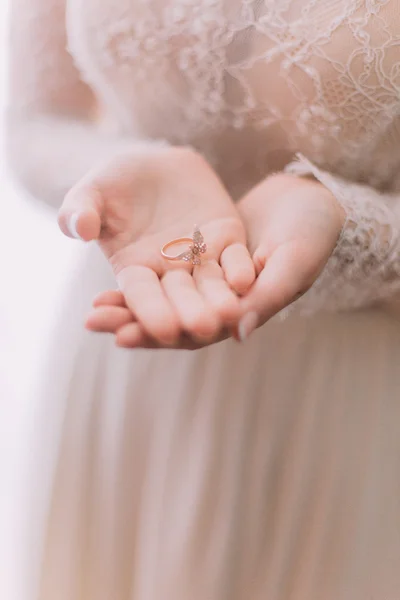 Bride delicately holding fancy wedding ring on her hands — Stock Photo, Image