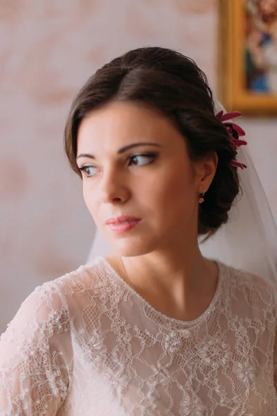 Close-up retrato de noiva bonita em vestido de noiva olhando sobre seu ombro dentro de casa — Fotografia de Stock