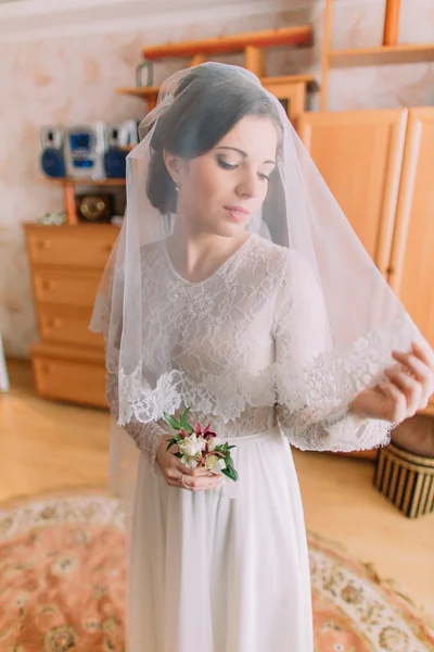 Primer plano retrato de la novia hermosa en vestido de novia con velo posando en el interior en el vestidor —  Fotos de Stock