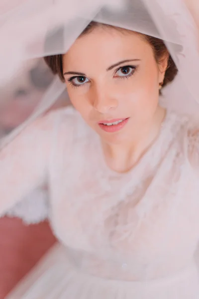 Close-up retrato de bela noiva sensual no vestido de casamento levantando sua formiga véu olhando para a câmera de desvantagem — Fotografia de Stock