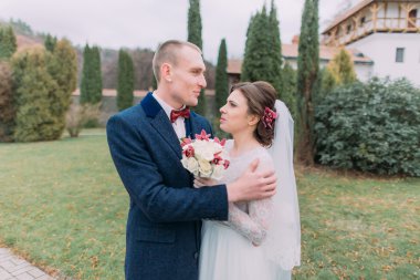 Yakışıklı damat şefkatle her iki yeşil park gezinme sırasında yeni eşi kucaklayan