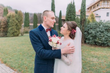 Yakışıklı damat şefkatle yürürken her iki yeşil park zarif yeni karısı kucaklayan