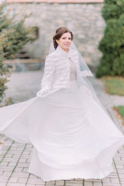 Güzel düğün elbisesi sallayarak yeşil park döşeli yolda poz güzel zarif gelin