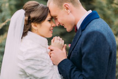 Mutlu enloved yeni evli çift, ihale gelin ve nazik damat, birlikte yeşil parkta yürürken elele