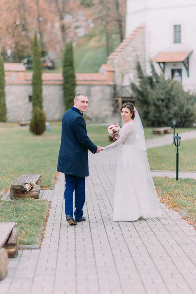 Härlig nygift par på bröllop dag promenader utomhus på vacker grön park — Stockfoto
