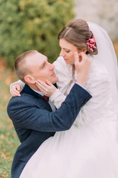 Ευτυχισμένο νιόπαντρο ζευγάρι στο φθινοπωρινό πάρκο. Κομψή νύφη στα γόνατα του όμορφου νέου συζύγου της — Φωτογραφία Αρχείου