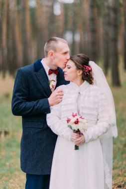 Mutlu şık yeni evli çifti kozalaklı ormanda poz. Yarım uzunlukta portre