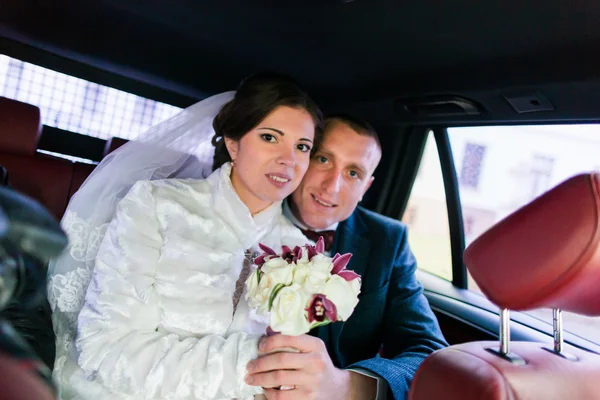 Portrait de couple heureux jeune marié en voiture après la cérémonie de mariage — Photo