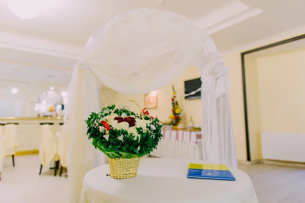 Arco de boda en el interior del restaurante luminoso decorado y servido para la celebración del matrimonio. Primer plano en la mesa con ramo floral — Foto de Stock