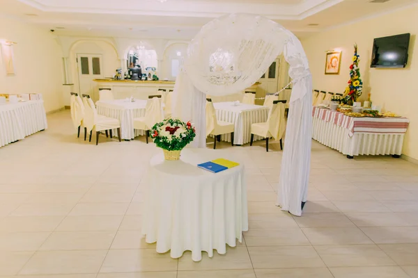 Arco de casamento em restaurante brilhante interior decorado e servido para a celebração do casamento — Fotografia de Stock