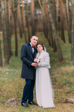 Güzel sadece evli çift yeşil Conifer Woods birbirlerine tutan poz. Tam uzunluklu açık portre