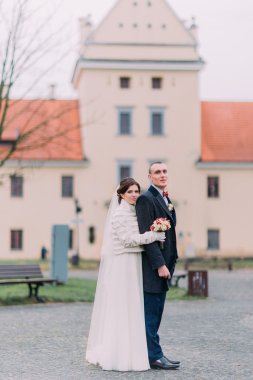 Güzel düğün çifti, şık gelin ve yakışıklı damat, park arka plan ile bir castle yakınındaki poz