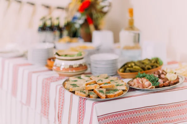 Close-up van verschillende zoute snacks en augurken in etnische aardewerk op horeca tafel banketzaal — Stockfoto