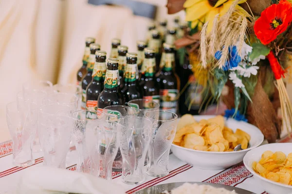 Mesa de catering de lujo. Diferentes aperitivos salados junto con la línea de botellas de cerveza — Foto de Stock