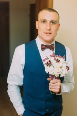 Şık giyinmiş adam gül zarif buket tutan kapalı poz