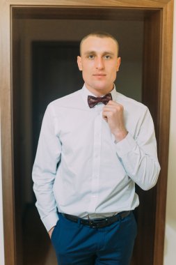 Otel odasının kapı kasaları ayakta poz heyecanlı damat