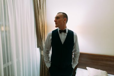 Otel odasının kapı kasaları ayakta poz heyecanlı damat