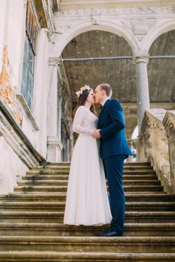 Her ikisi de antik palace taş merdivenlerde durup iken holding eller güzel gelini ile sevgi dolu. Düşük açısı Shot