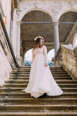Uzun beyaz gelinlik ve çiçek çelenk antik palace taş merdivenle iniyor büyüleyici gelin