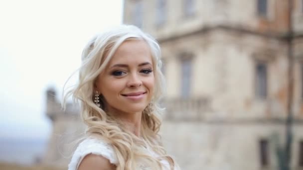 Hermosa novia rubia elegante posando en la antigua muralla medieval del castillo — Vídeos de Stock