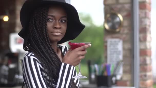 Великолепная африканская деловая леди пьет коктейль в баре, ожидая кого-то — стоковое видео