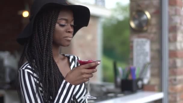 Linda senhora de negócios afro-americana bebendo coquetel vermelho no bar e desfrutando de sua bebida — Vídeo de Stock