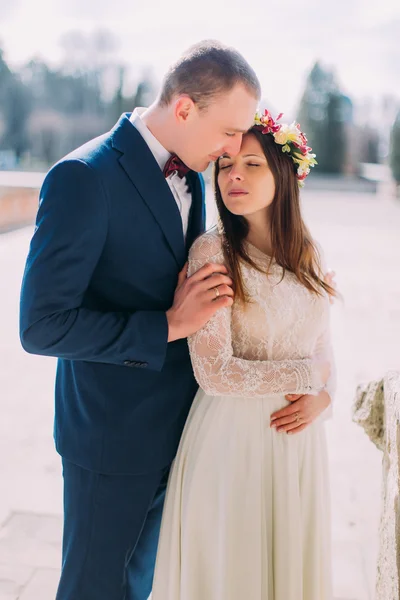 Portrait of sweet sensual wedding couple embracing. Beautiful young bride embraces with handsome groom outdoor — Stock Photo, Image