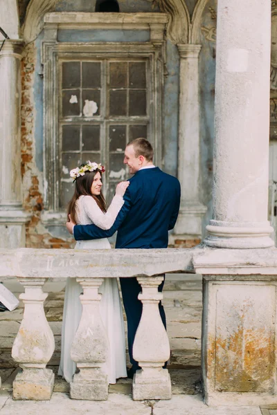 Sensual marido y mujer abrazándose cerca de la balaustrada en antiguo palacio en ruinas. Vista trasera — Foto de Stock