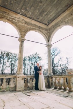 Şehvetli karı koca antik harabe sarayda veranda kemerleri altında sarılma