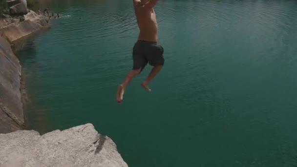 Hombre rubio saltando del acantilado al agua. Estilo de vida divertido verano — Vídeos de Stock