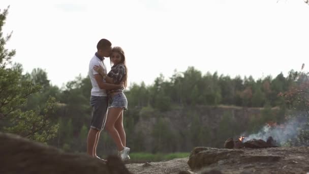Amante casal viajante abraça enquanto relaxa no acampamento da floresta com fogueira — Vídeo de Stock