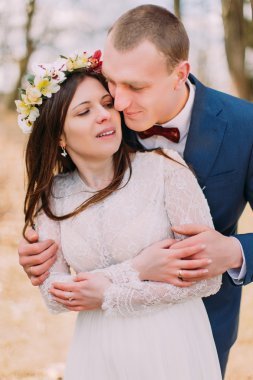 Şık yeni evli gelin ve damat düğün portresi mutlu arka planda yapraksız ağaçlar ile açık kucaklayan