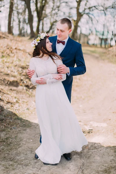 Svatební portrét šťastného stylového novomanželé nevěsty a ženicha, který se na pozadí nachází venku s listovními stromy — Stock fotografie