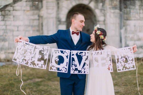 Щасливий щойно одружений наречений і наречений тримають художні паперові любовні листи — стокове фото