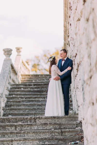 Счастливая супружеская пара стоит на старинной каменной лестнице. Портрет в полный рост — стоковое фото